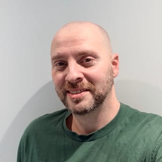 Vio, founder of MyPetSitter, smiling, in a green T-shirt